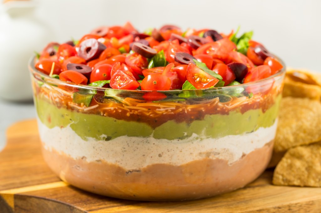 7-layer tex-mex dip recipe by Mama Kelce in bowl with chips