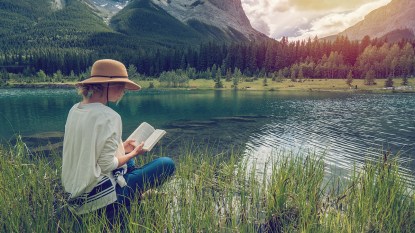 woman reading in a beautiful lake setting: armchair travel
