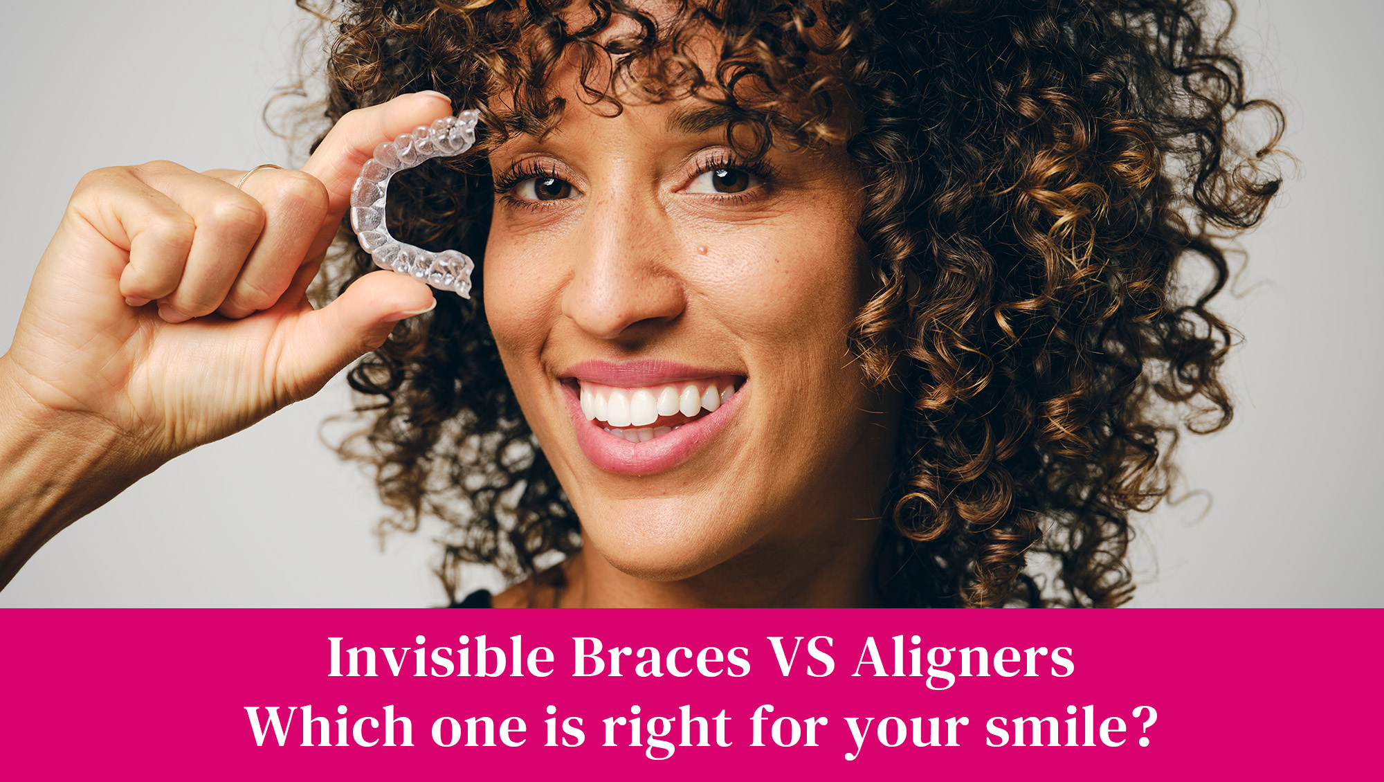 Woman holding up aligners, as opposed to using braces.