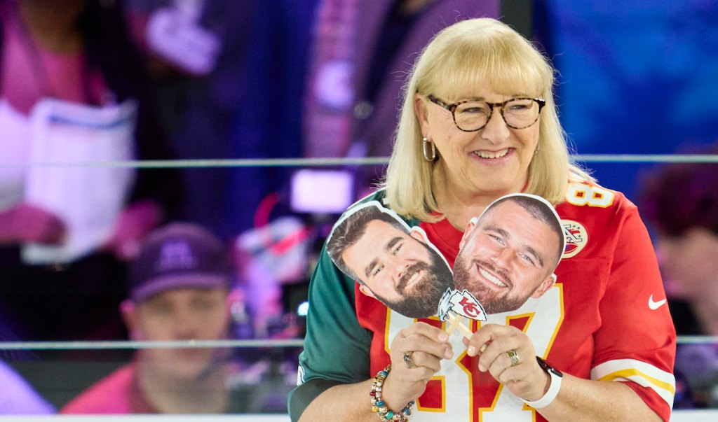 Donna Kelce holds photos of her sons, Travis and Jason, in 2023 Mama Kelce advice