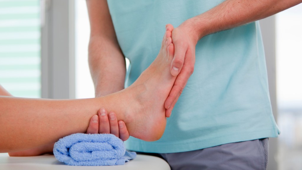 A close up of a pan examining a woman's foot during physical therapy