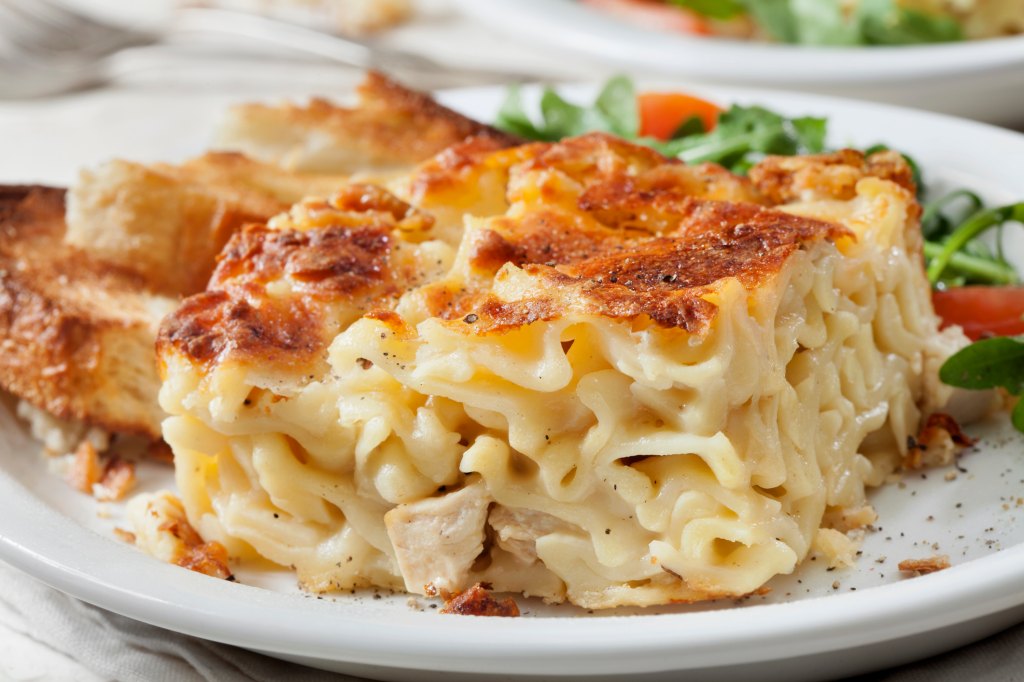 Piece of cooked chicken and spaghetti casserole dish with cheesy and cream of mushroom soup