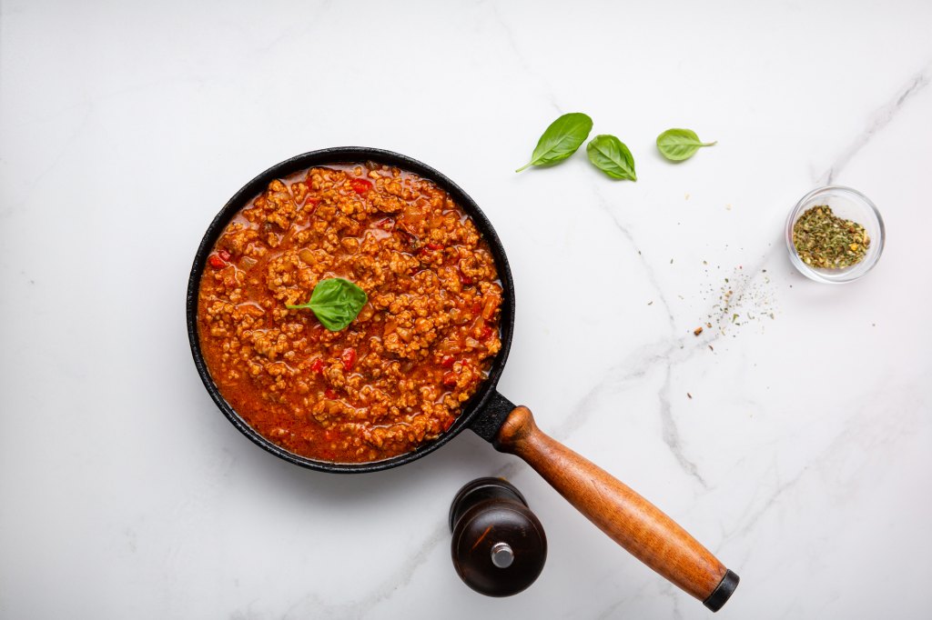 pot of bolognese meat sauce on marble surface