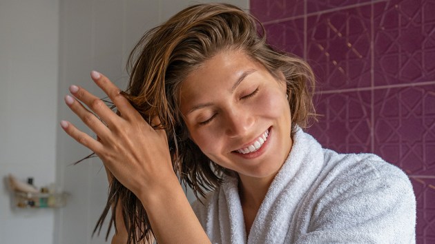 Woman air drying her hair after learning how to air dry hair