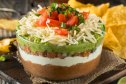 Mama Kelce's 7-layer Tex-Mex dip in large bowl with chips