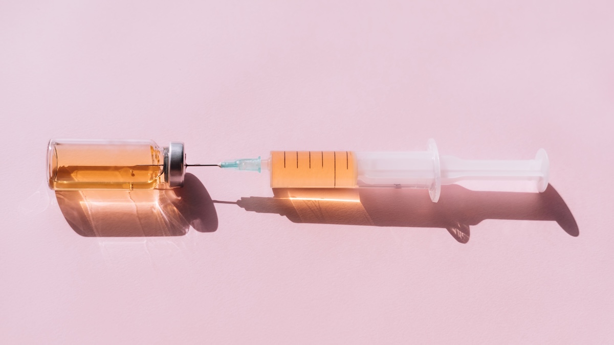 Ozempic vs. Wegovy? An injectable medication is held against a pink background.