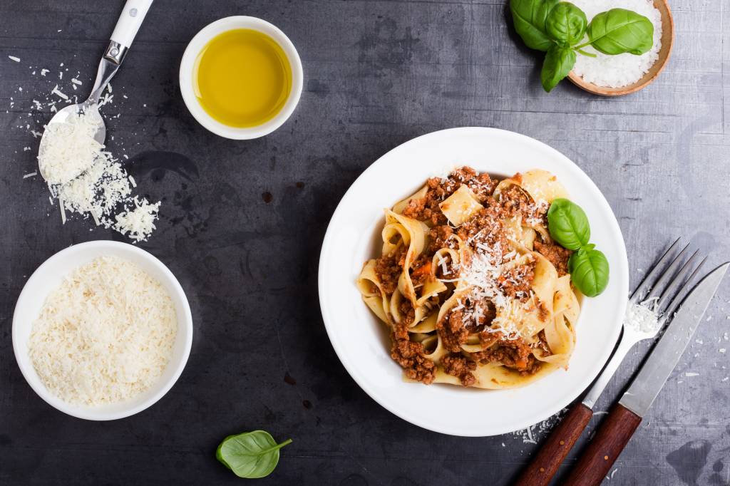 Italian pappardelle bolognese in bowl on rustic table