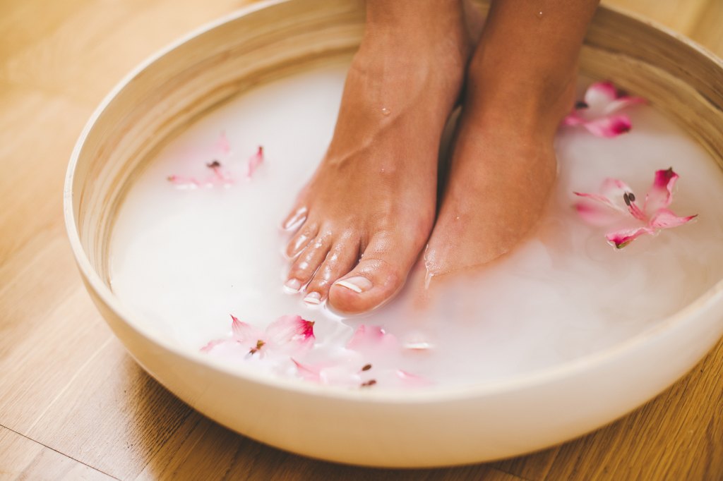 Woman doing a foot soak, one of the warm beauty treatments