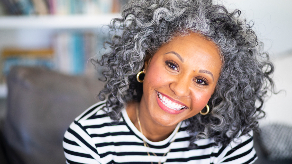A woman in a black and white striped shirt with a bright, while smile