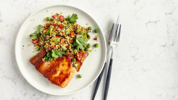 Grilled Salmon and Quinoa on a white plate with a silver fork and knife