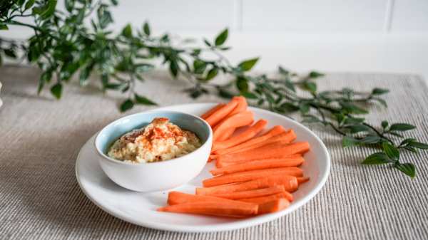 hummus and carrots on a white plate