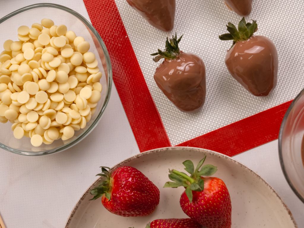 ingredients for chocolate dipped strawberries, fresh strawberries and bowl of white chocolate chips