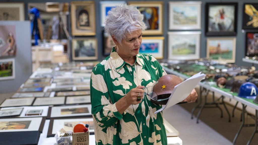 A woman looking at items at an auction house