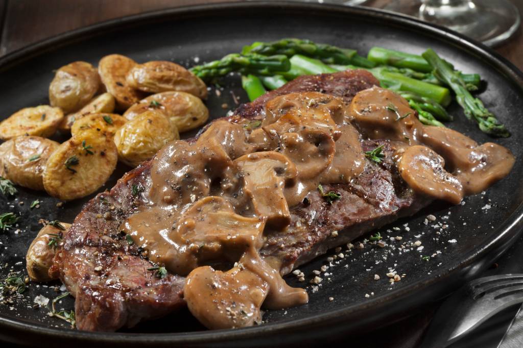 classic Steak Diane with sauce, roasted potatoes and asparagus