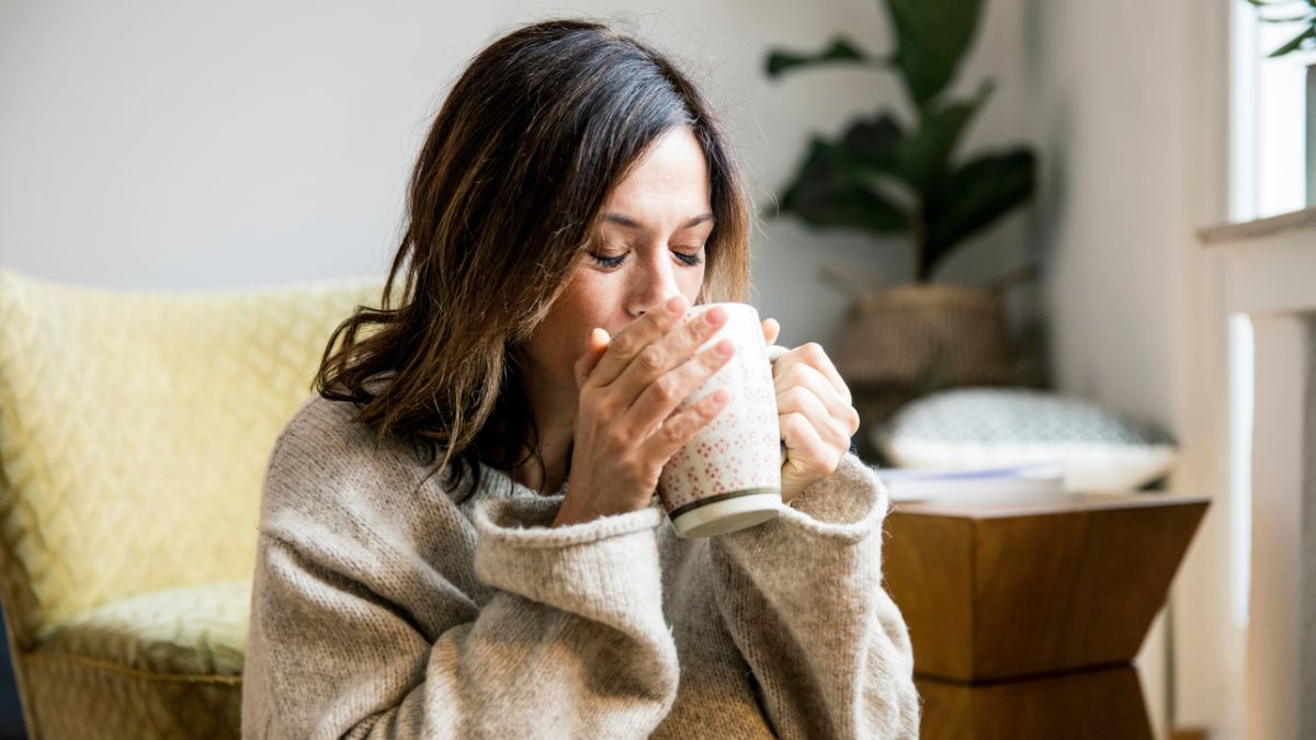 woman sipping herbal tea after researching how to treat swollen lymph nodes in neck naturally
