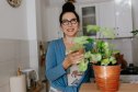 mature woman holding a new houseplant to reduce indoor air pollution