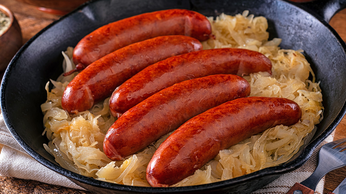 Kielbasa cooked in the air fryer being served on a bed of sauerkraut
