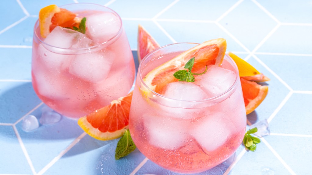 Pink grapefruit mocktails topped with fresh fruit to fight stress belly