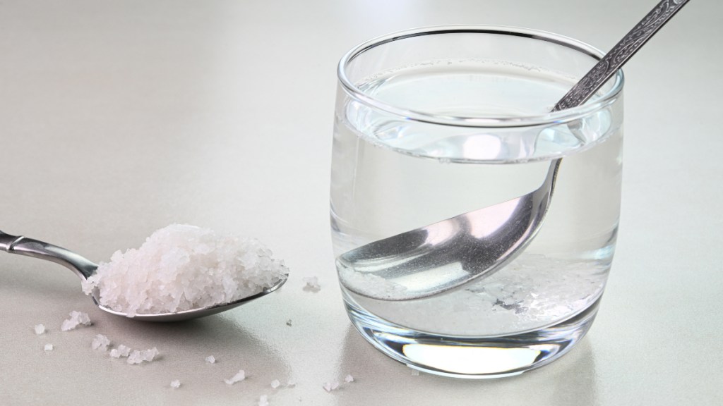 A cup of a water with a spoon of Epsom salt for constipation