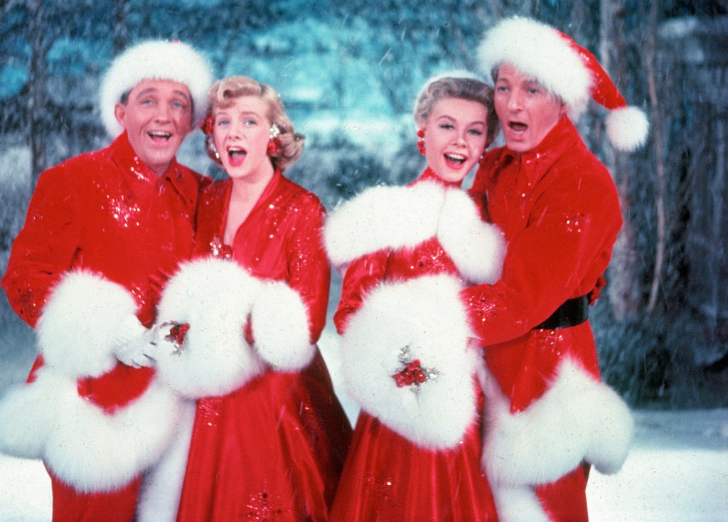 American actors Bing Crosby (1903 - 1977), Rosemary Clooney (1928 - 2002), Vera-Ellen (1921 - 1981), and Danny Kaye (1913 - 1987) sing together, while dressed in fur-trimmed red outfits and standing in front of a stage backrop, in a scene from the film 'White Christmas,' directed by Michael Curtiz, 1954