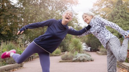Two women leaning on each other as they try balance, which helps ward off the stages of osteoporosis