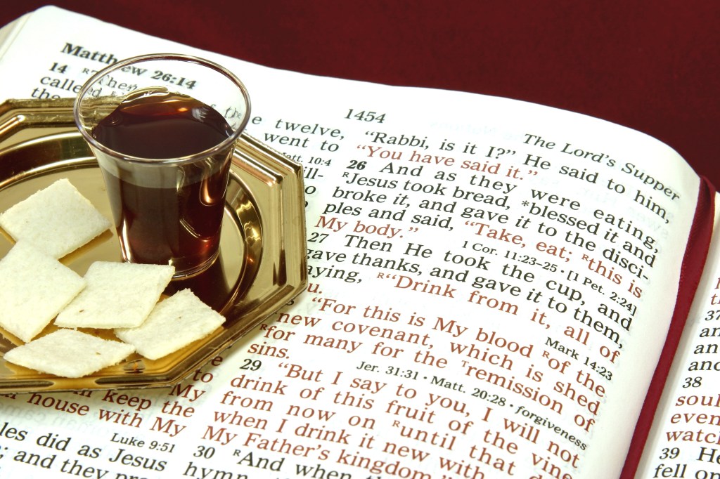 Communion bread and wine with Bible open to The Lord's Supper