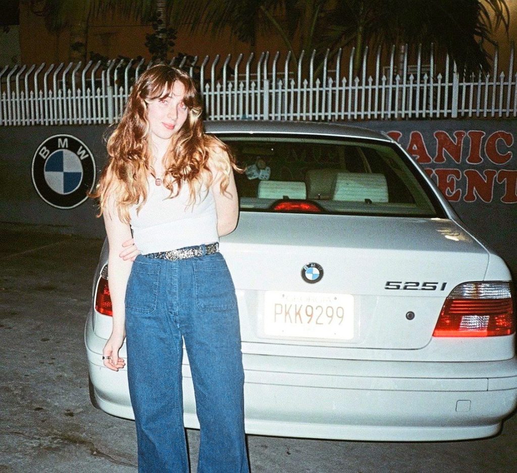 Grown-up Natalie with the blue BMW given to her by her grandmother