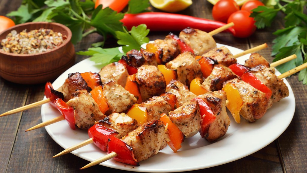 Plate of pork kebabs on skewer as part of a Mediterranean diet to get results