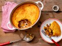 Cowboy casserole with cornbread, beef, beans, corn and cheese in baking dish and slice on plate