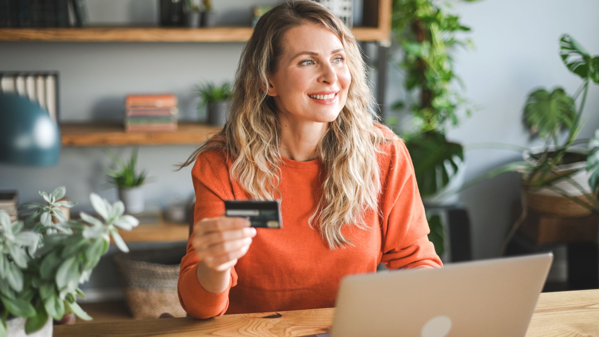 woman using debit card to pay bill on her phone