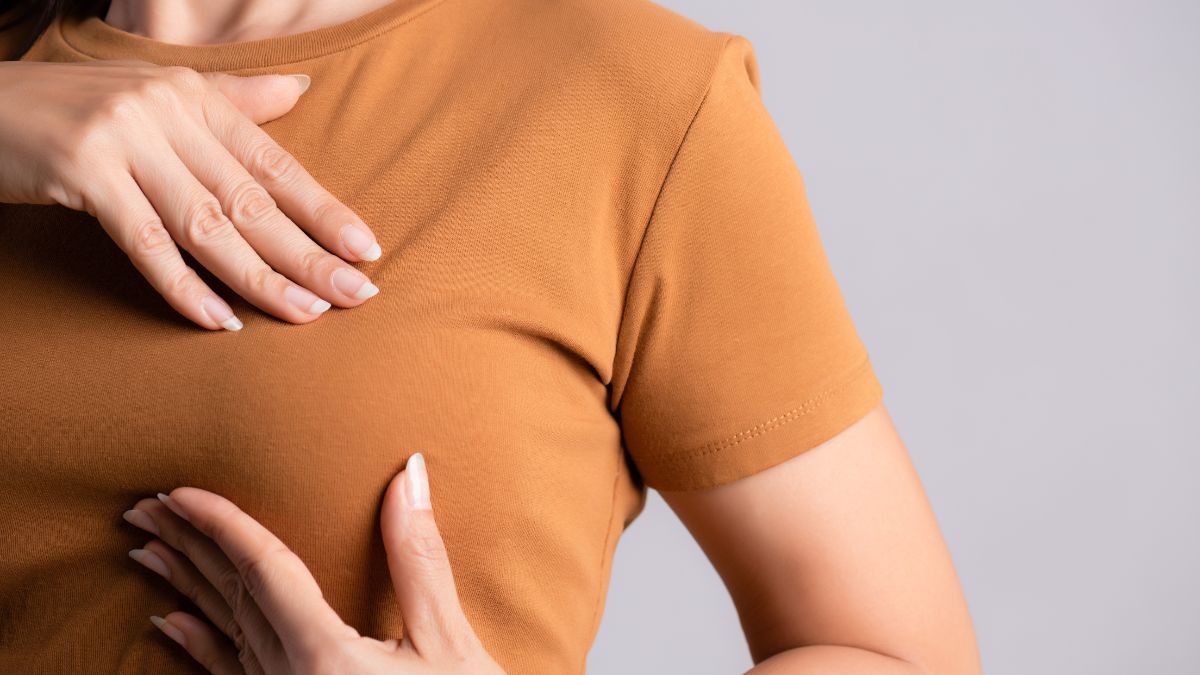closeup of woman touching her breast wondering why do my nipples hurt