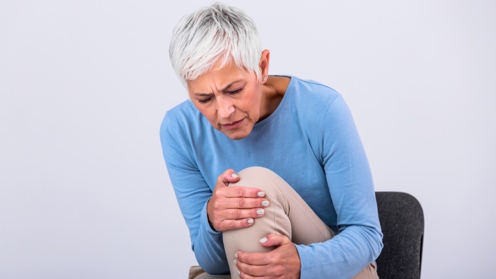 A mature woman holding her knee in pain