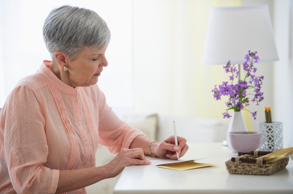 Woman sitting at desk writing a letter