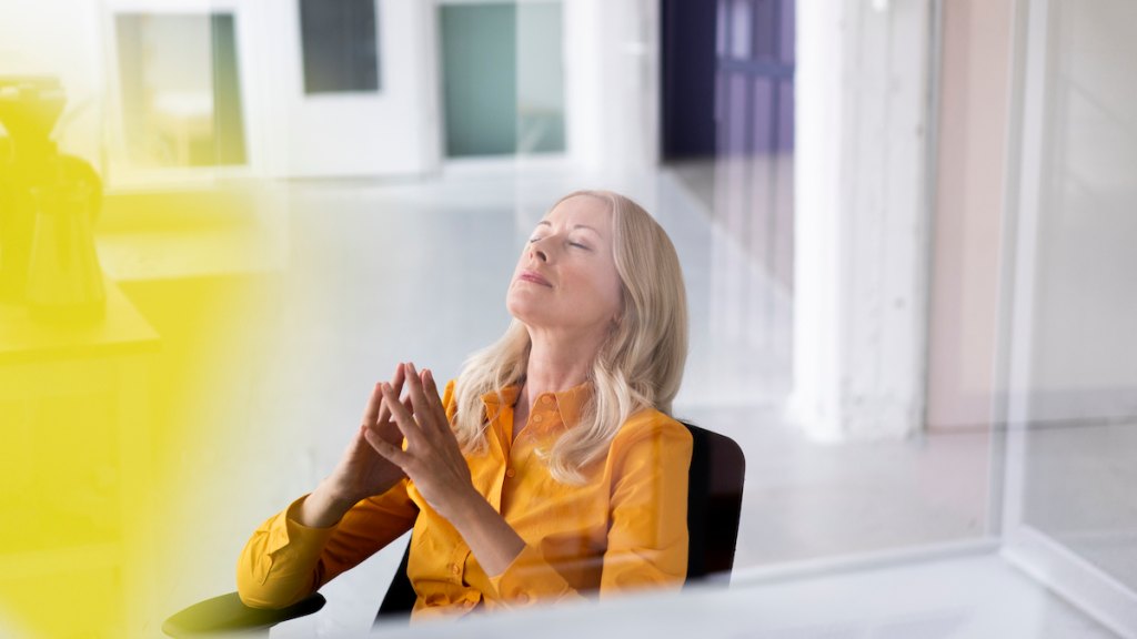 Woman sitting in office and taking a deep breath how to stop taking things personally