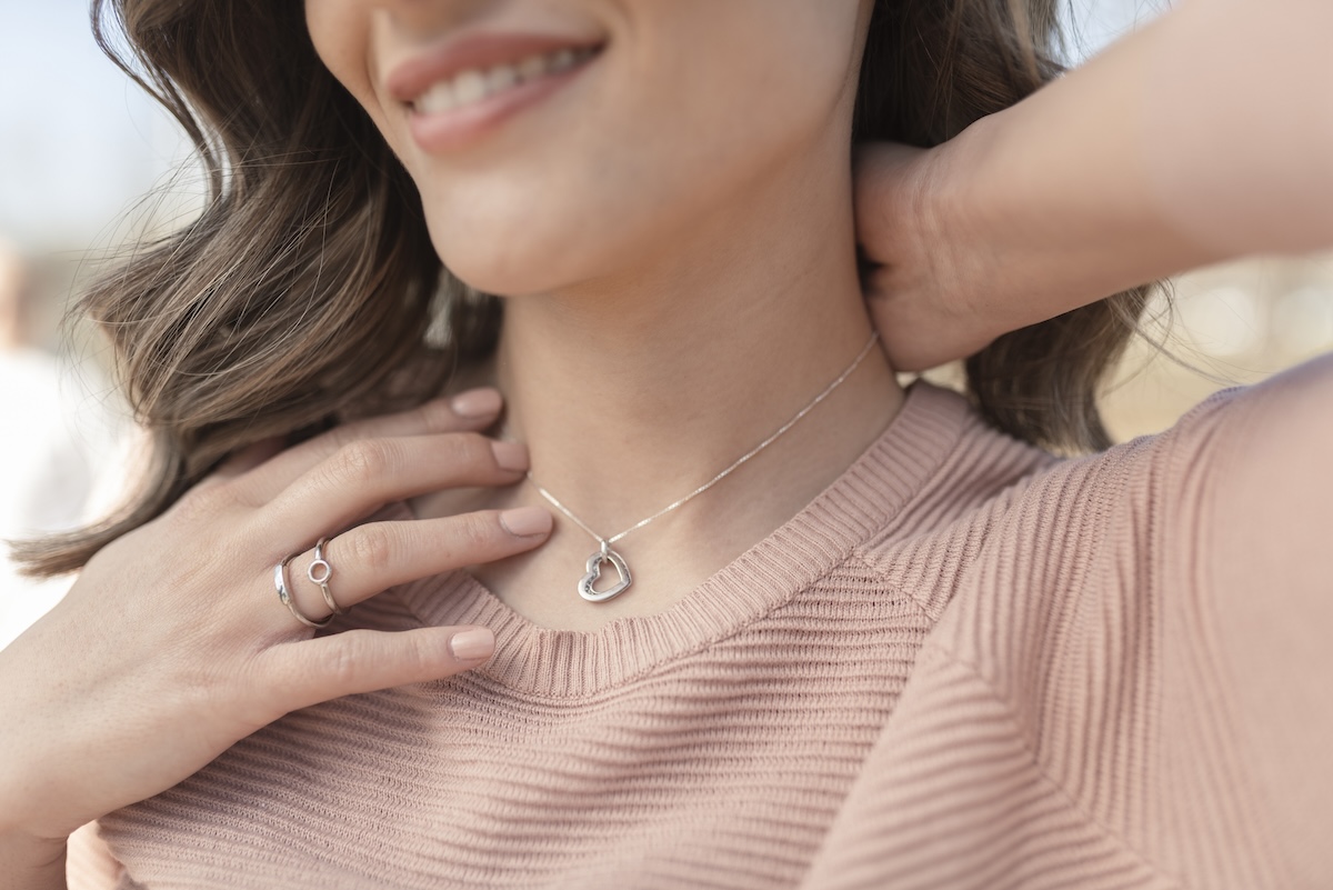 Close-up shot of a beautiful woman wearing beautiful silver necklace and rings