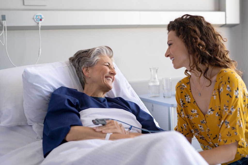 Woman visiting older woman in hospital for how to comfort someone who's sick