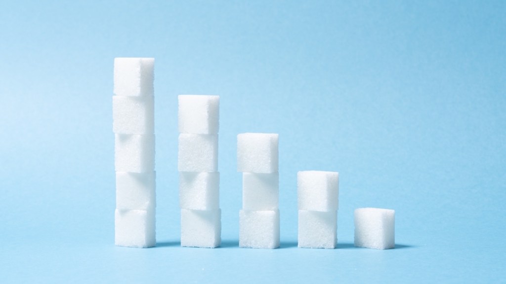 Gradually decreasing stacks of sugar cubes on a blue background