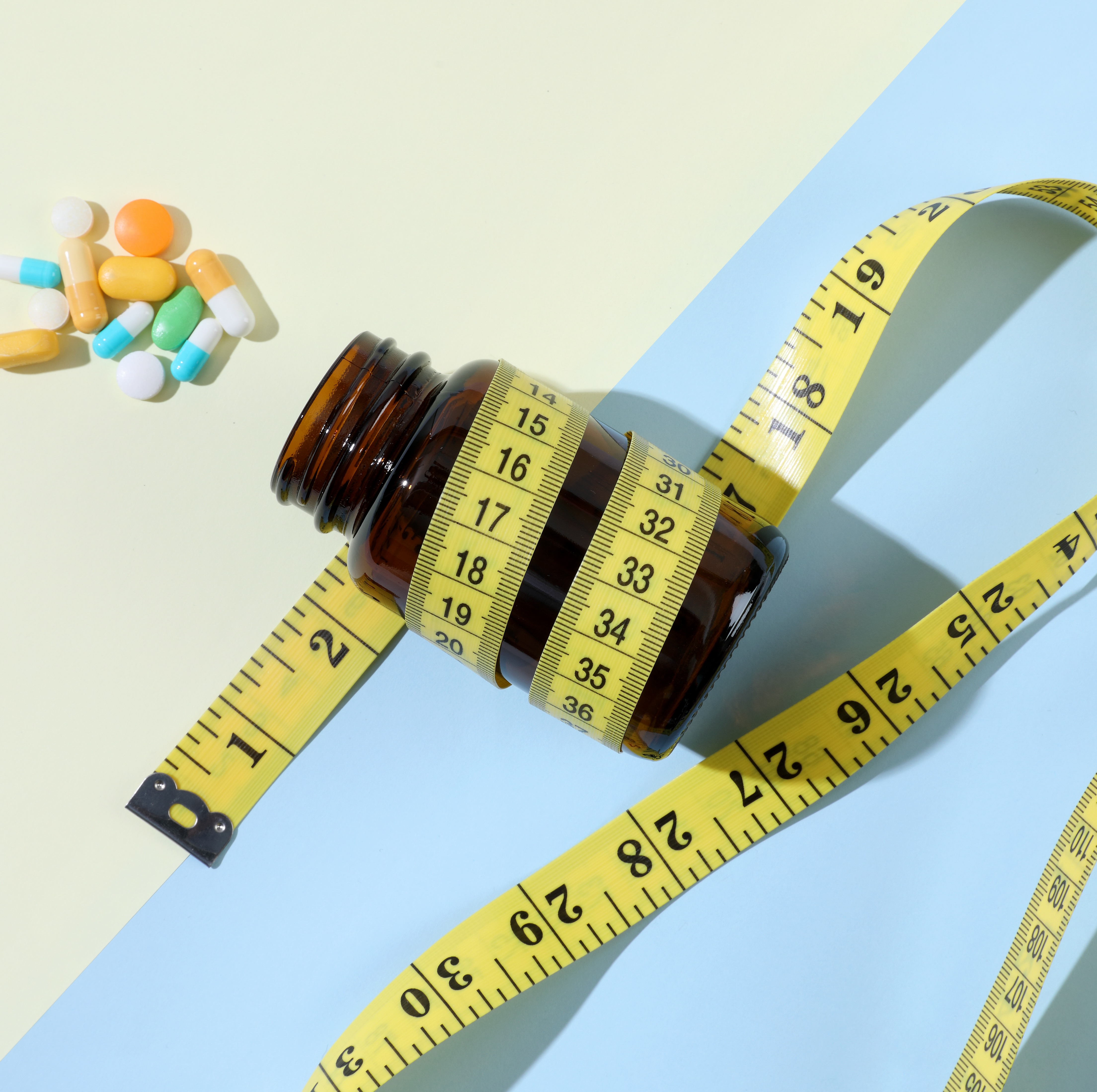 Measuring tape wrapped around pill bottle