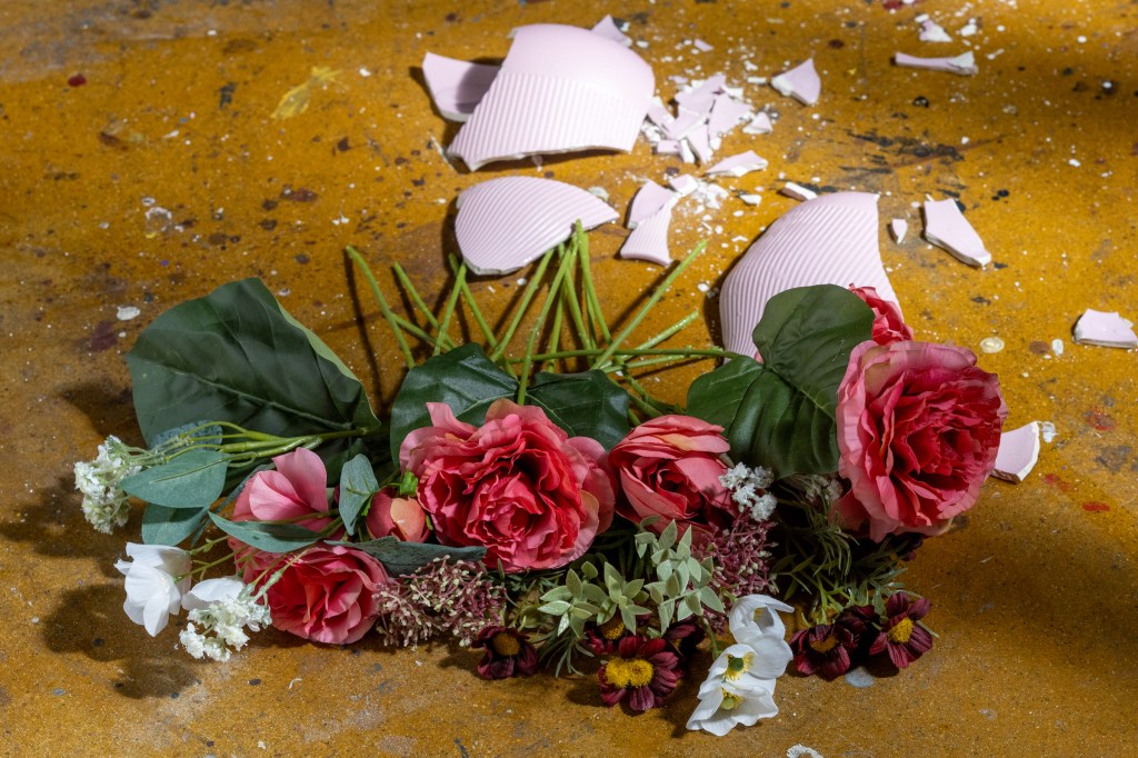 Flowers on the ground with a broken vase