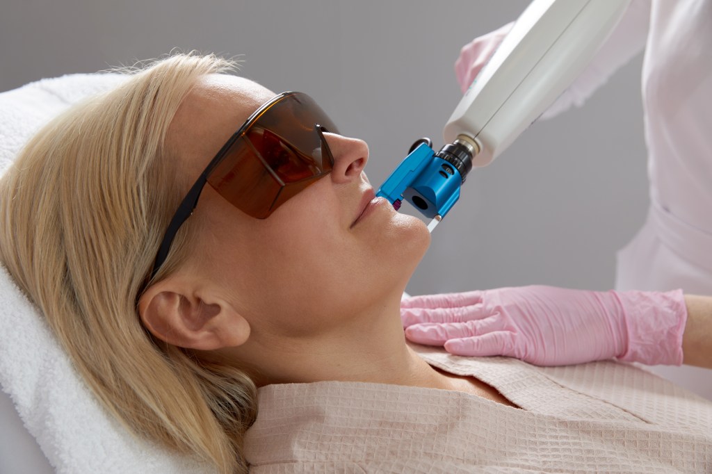 Woman getting a laser treatment, which is one way for how to get rid of textured skin
