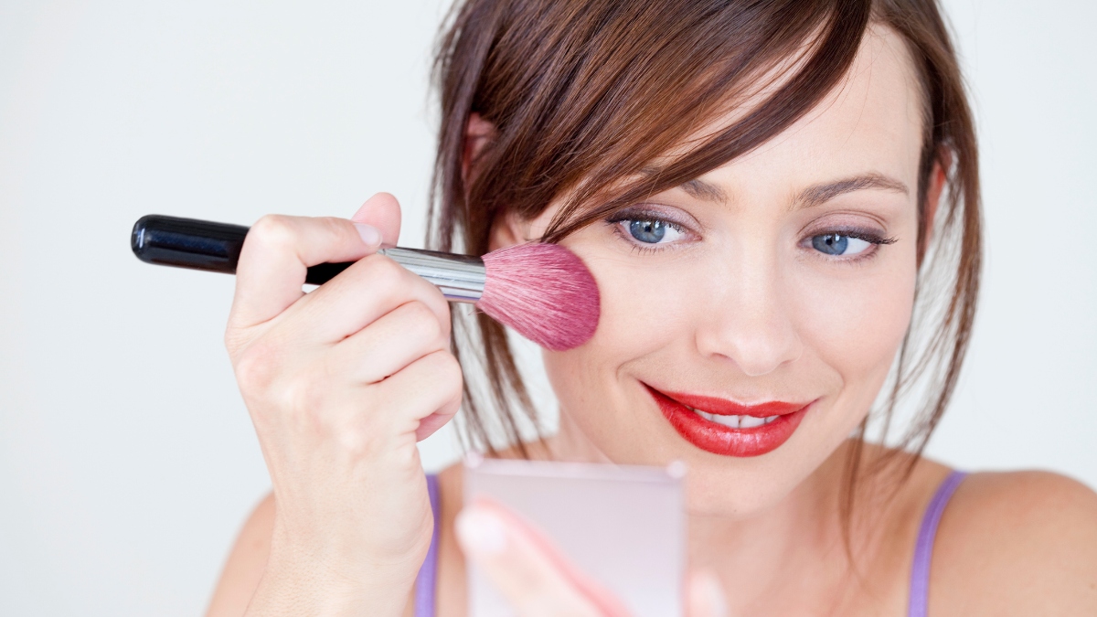 mature woman putting on purple blush