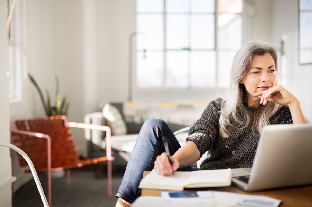 Woman sitting at desk thinking while working from home, how to stop taking things personally
