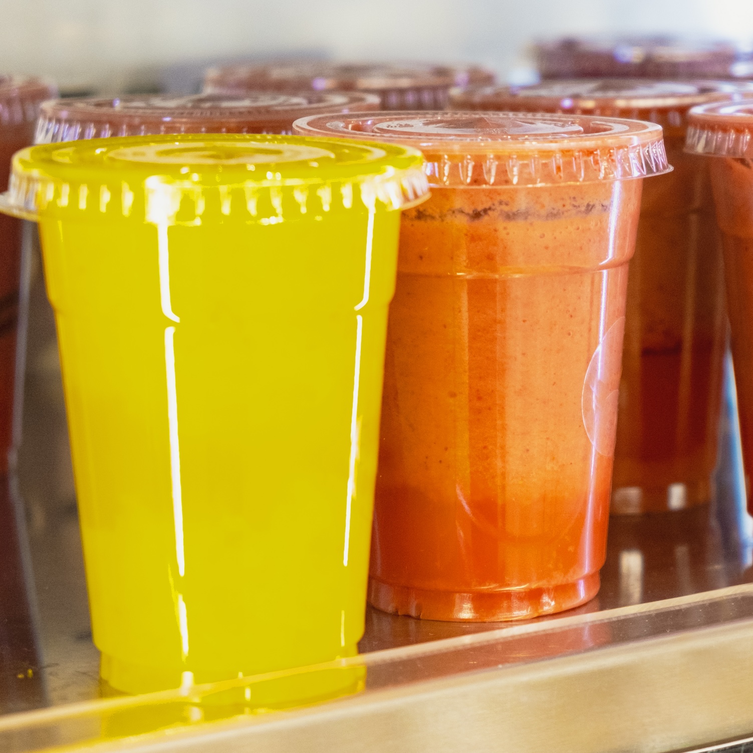 Store display with plastic cups with different color smoothies