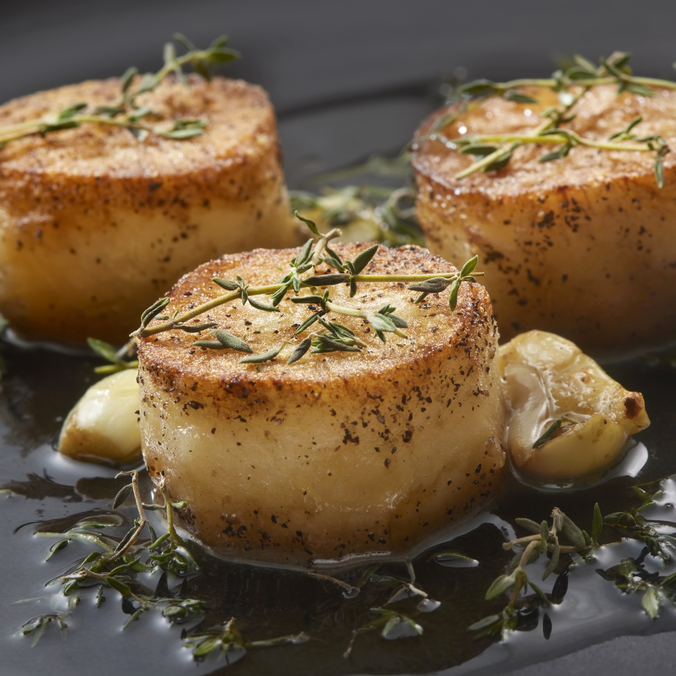 French Fondant or melting potatoes with garlic, rosemary, butter on plate