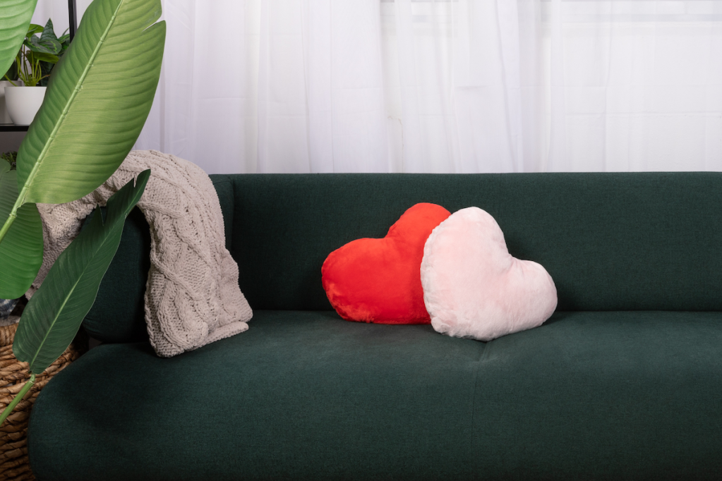 Two heart-shaped Hugimals pillows on couch