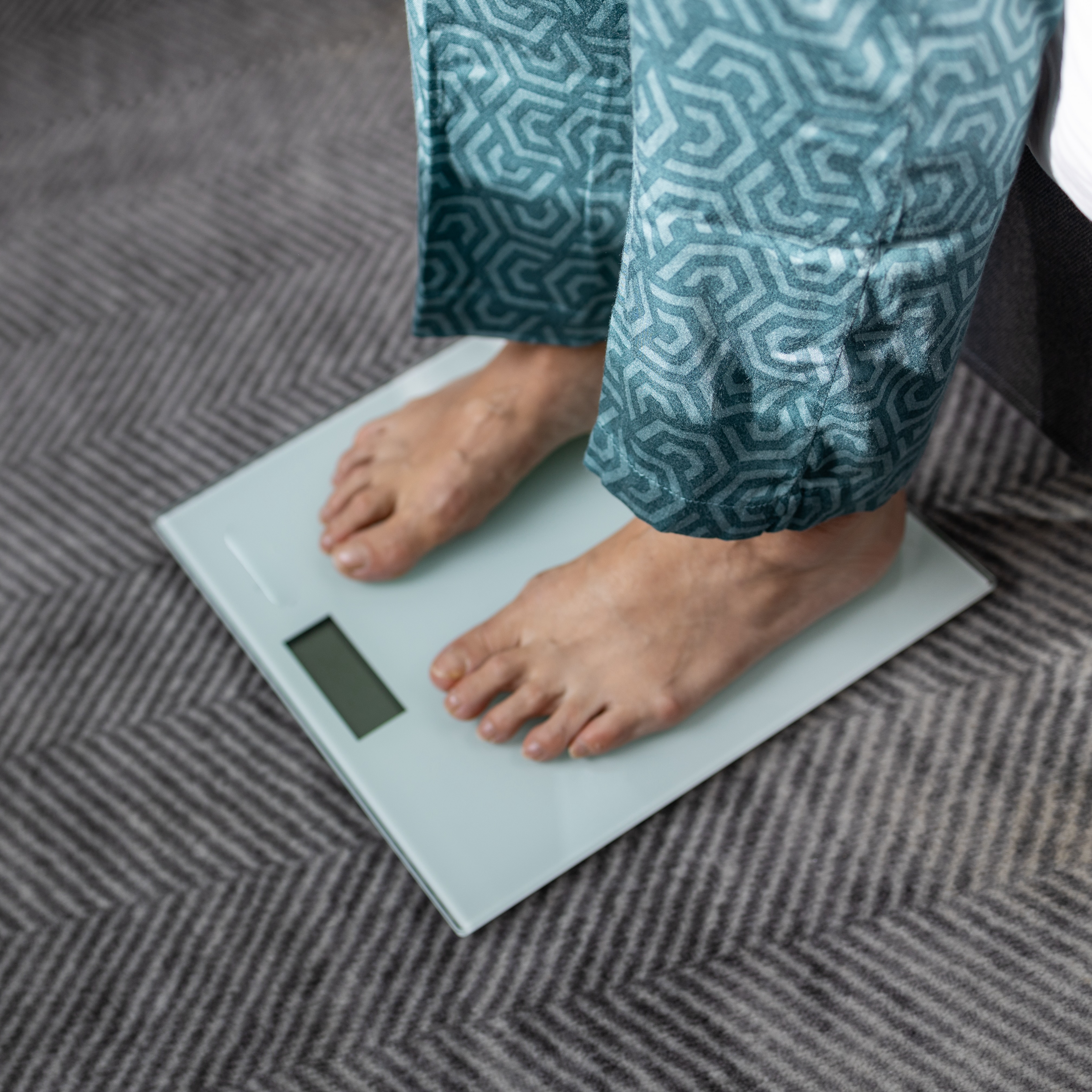 woman's feet on a scale as she wonders how much weight can you lose in a month