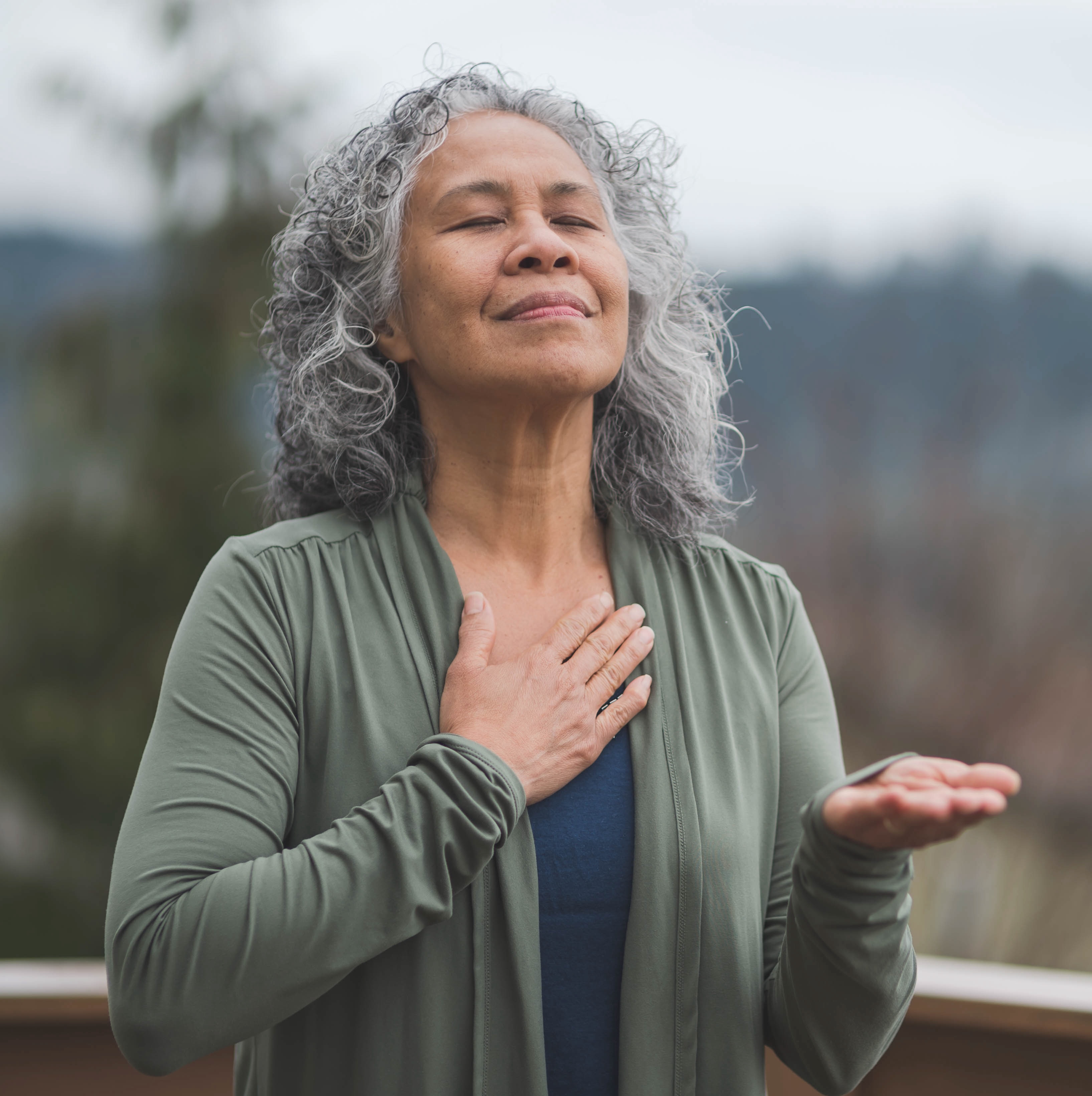woman pausing and meditating during a prayer walk outdoors