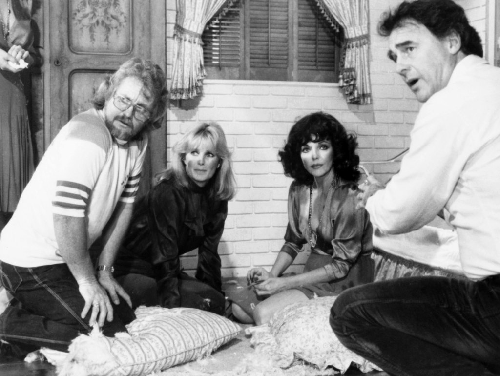 DYNASTY, from left, stunt coordinator Roy Harrison, Linda Evans, Joan Collins, director Jerome Courtland, on-set, for an episode aired August 11, 1982