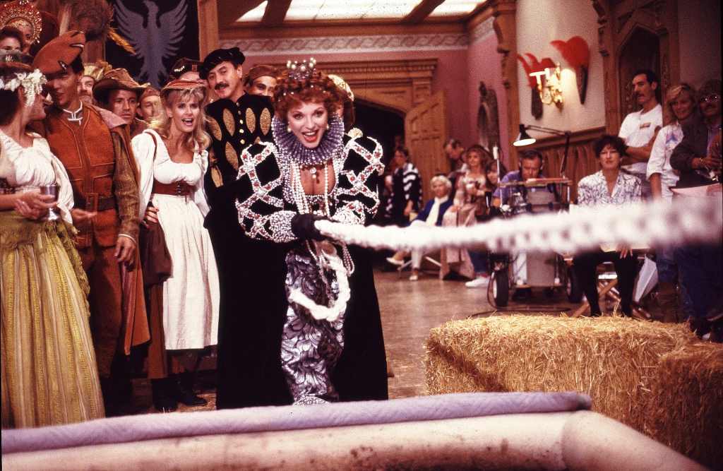 Joan Collins in a tug-of-war over a mud pit during filming of a medieval scene for the TV series Dynasty in September 1987