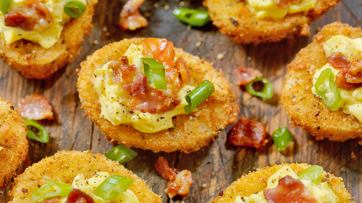 Fried deviled eggs on a wooden serving board